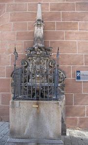 Ein Wandbrunnen aus der Renaissance am Hauptmarkt von Nürnberg, funktional im Kontext mit der Fleischbrücke